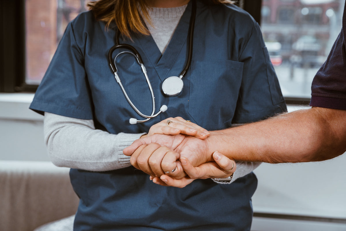 Nurse holding a patient's hand